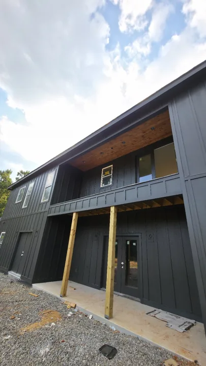 Board and batten siding around a recessed balcony with a wood ceiling