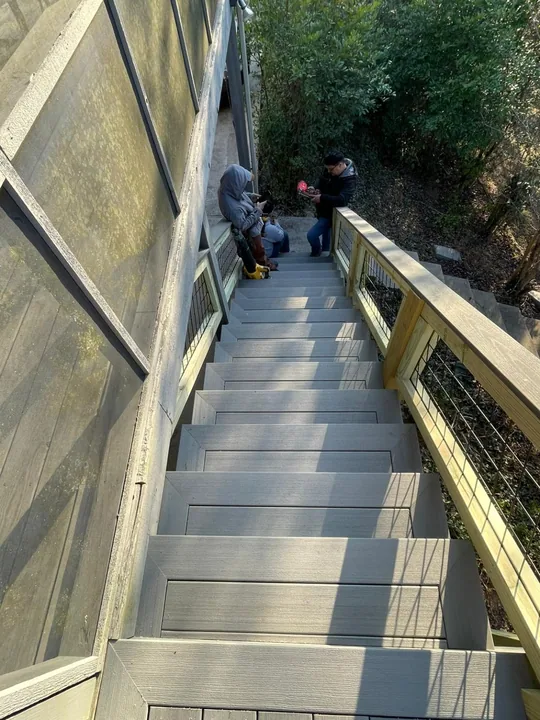 Gray deck stairs beside a screen porch