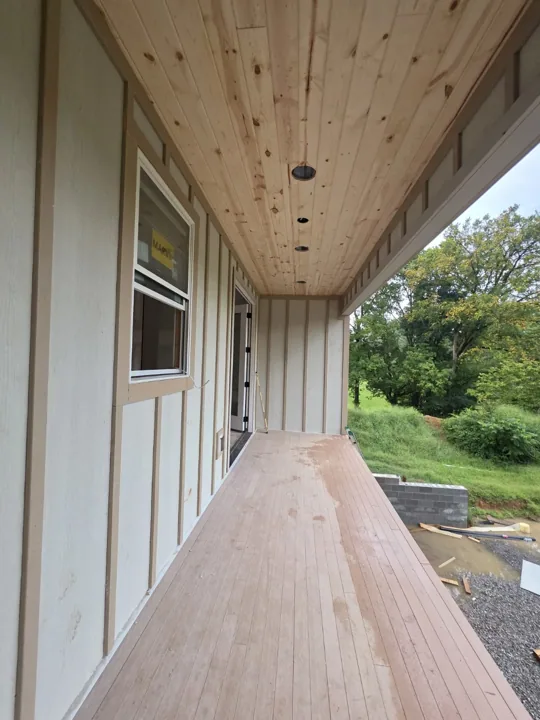 Natural wood ceiling along a covered porch before final lighting