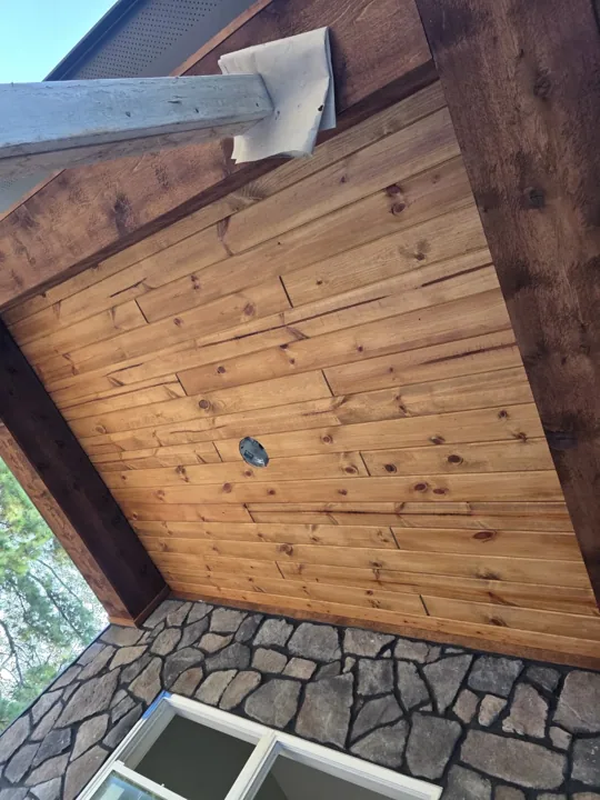 Wood porch ceiling with visible grain and dark trim