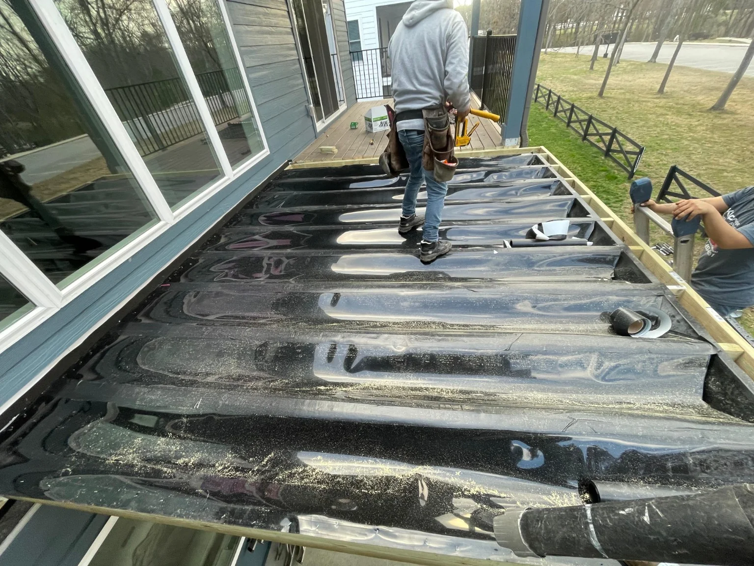 Trex RainEscape drainage troughs above the deck joists during an ERIE installation