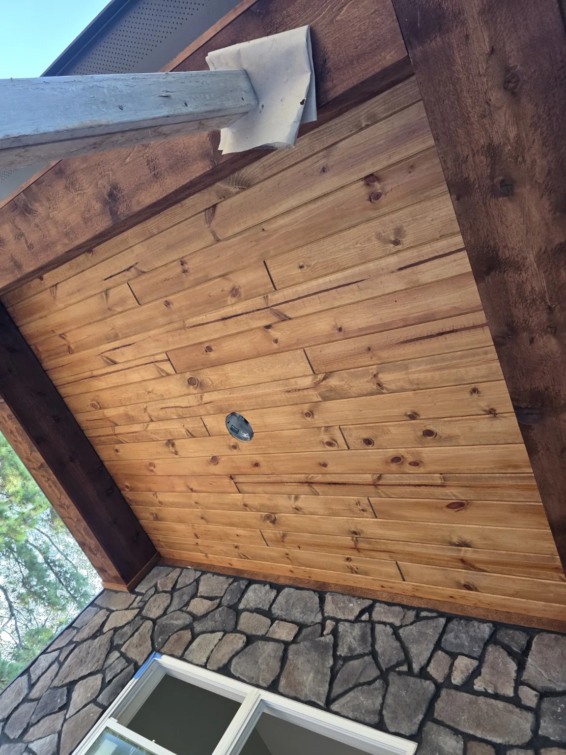 Natural wood porch ceiling with exposed wood grain on an ERIE Construction project